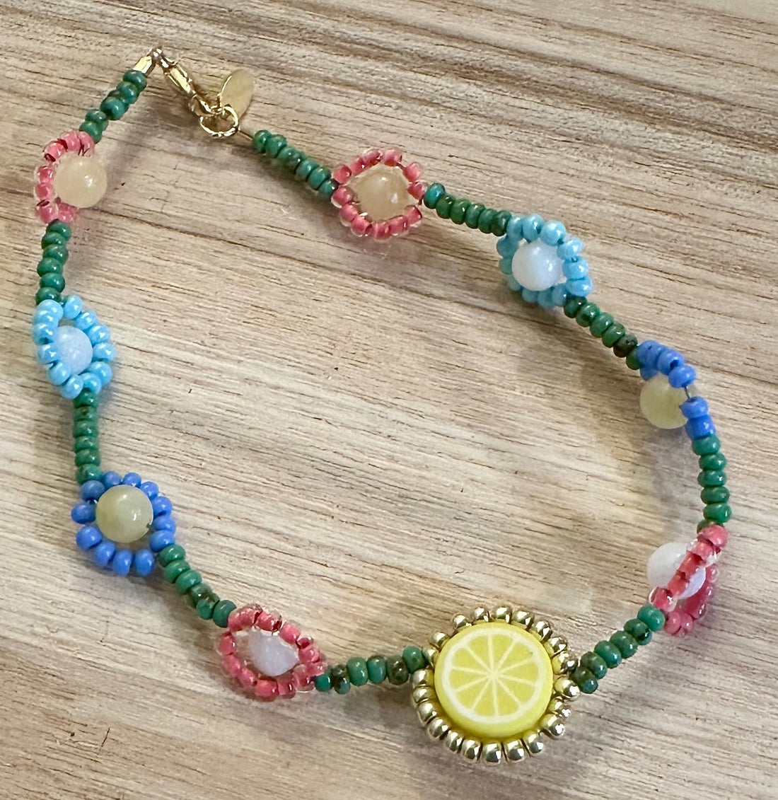 Eine Anleitung zum Fädeln von Blumen in ein Perlenarmband